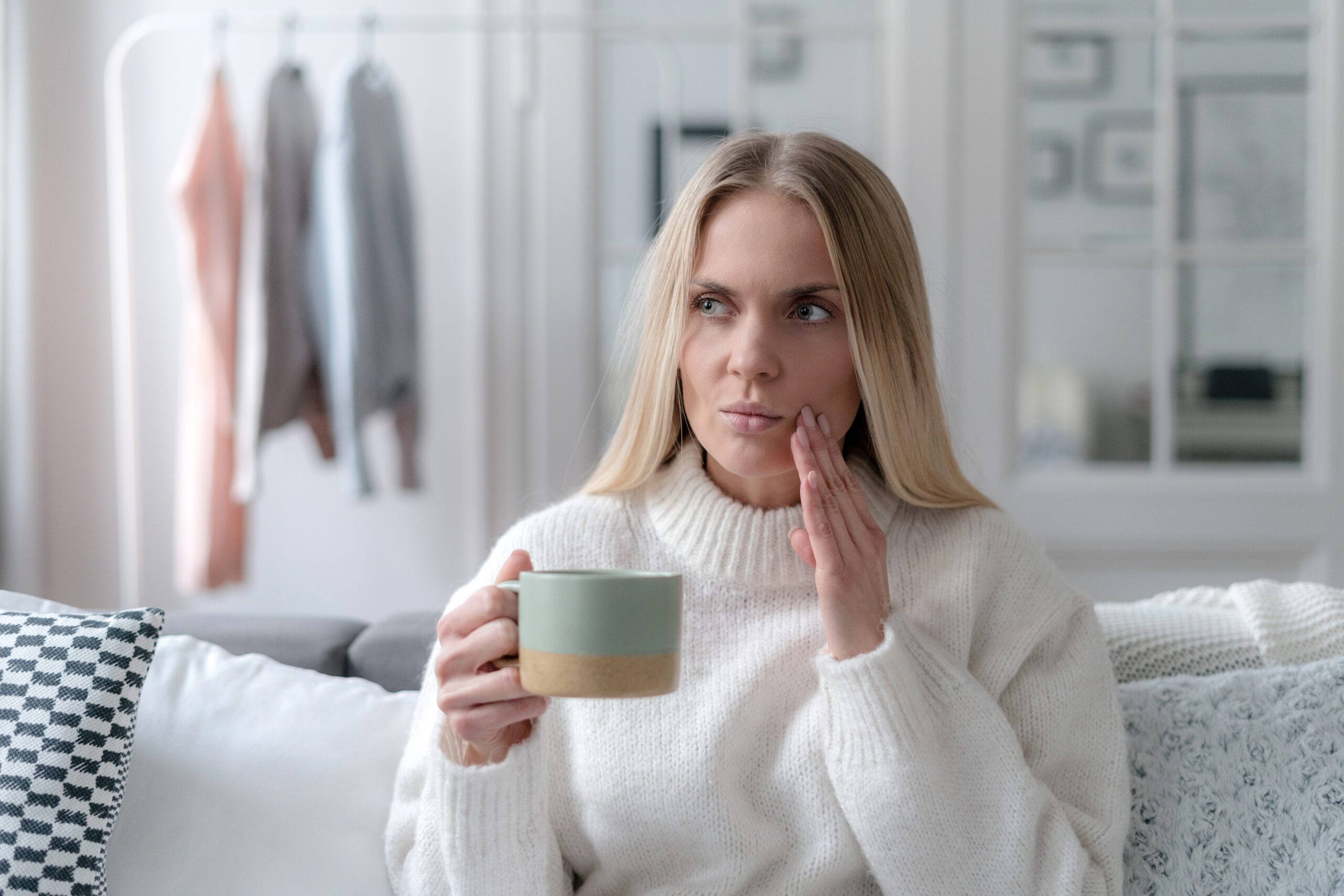 worried young woman with sensitive teeth feeling discomfort